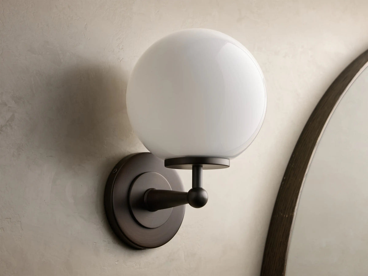 Fulton wall sconce in antique bronze with an unlit white milk glass globe