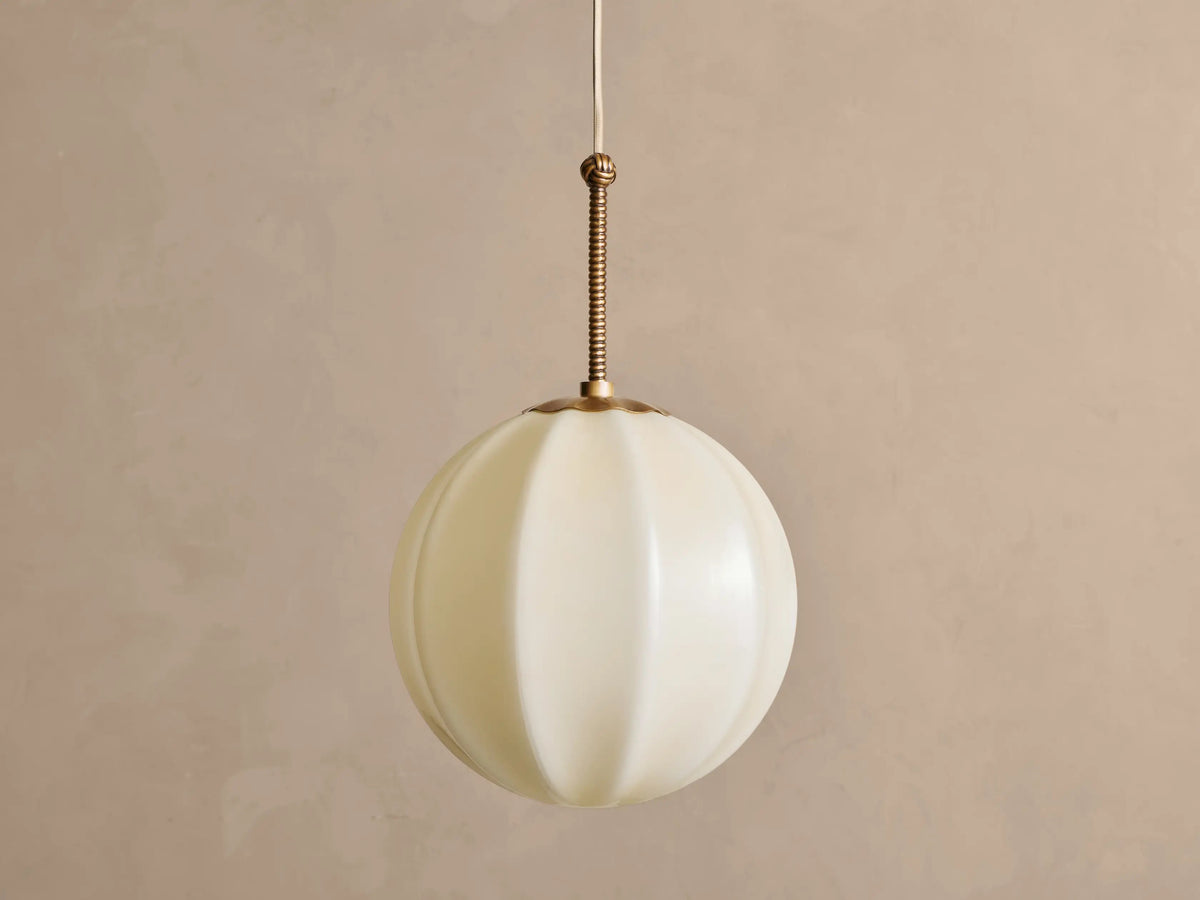 Agnes 12-inch cream glass pendant in antique brass, unlit front view