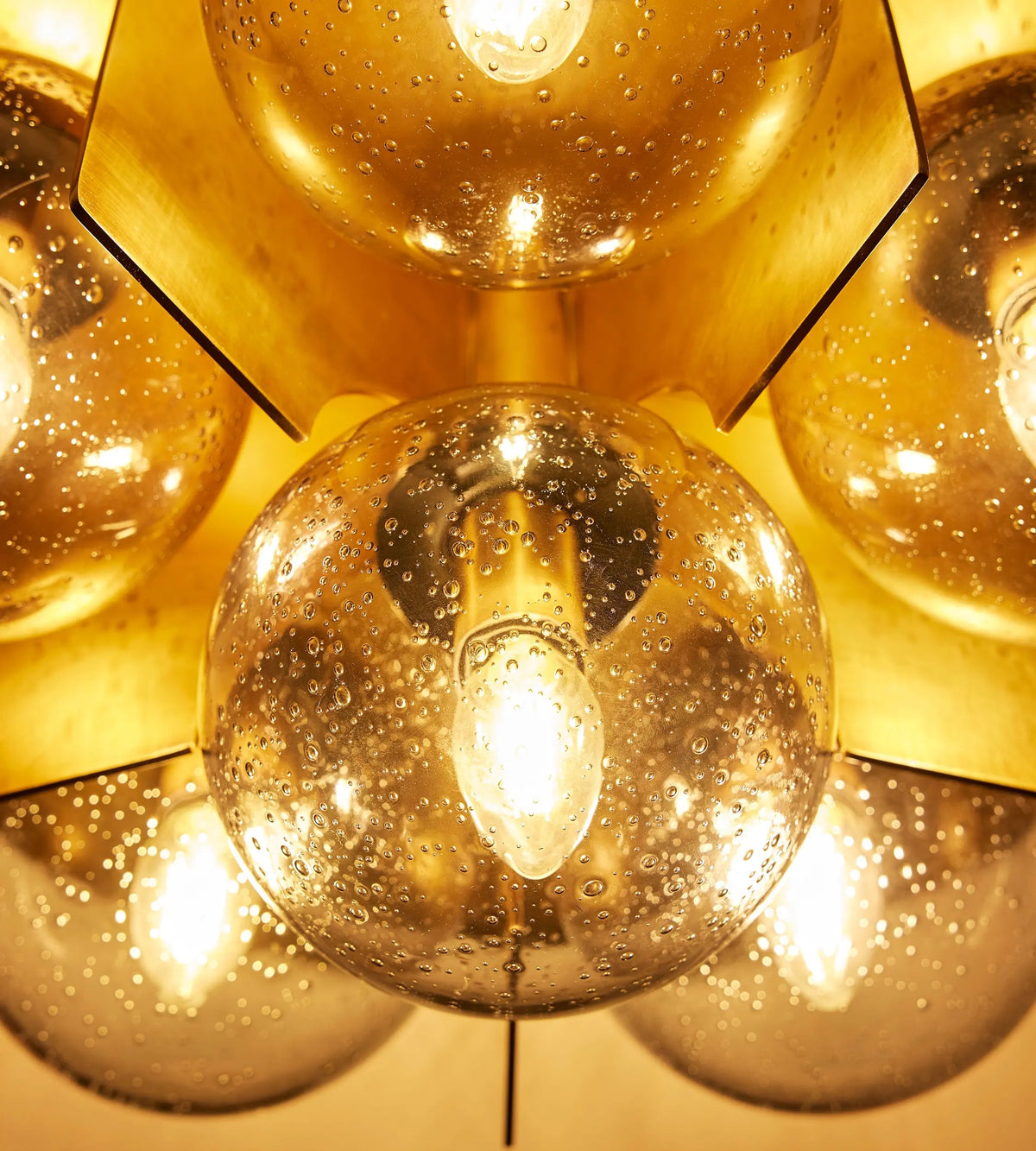 Close-up of Lois flush light bubble glass and antique brass panels