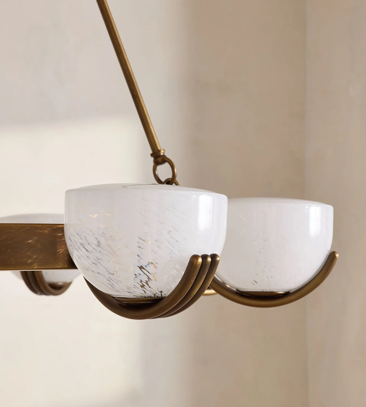 Close-up of Elber chandelier curved antique brass arm and glass holder