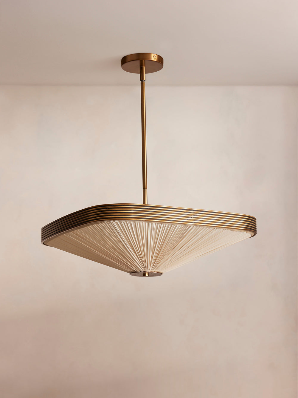 Attlee pendant light, front view with pleated cream silk shade and antiqued brass