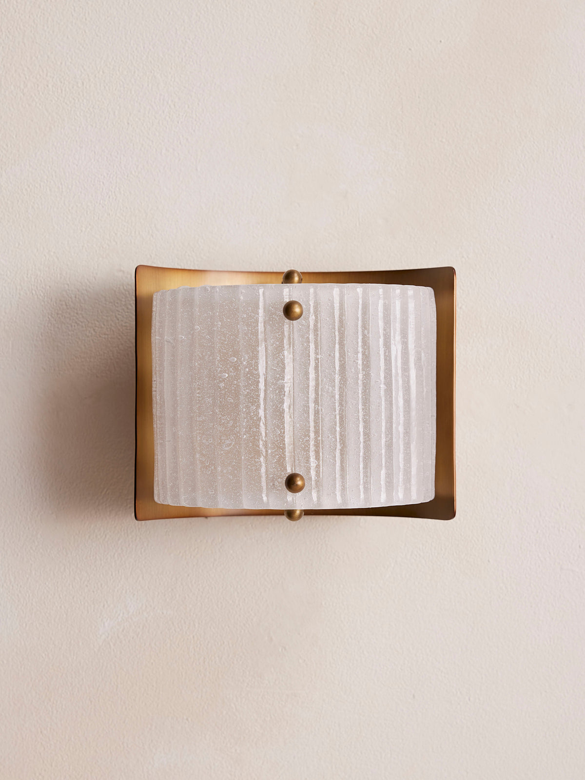 Bronte wall sconce unlit, front view of frosted ribbed glass