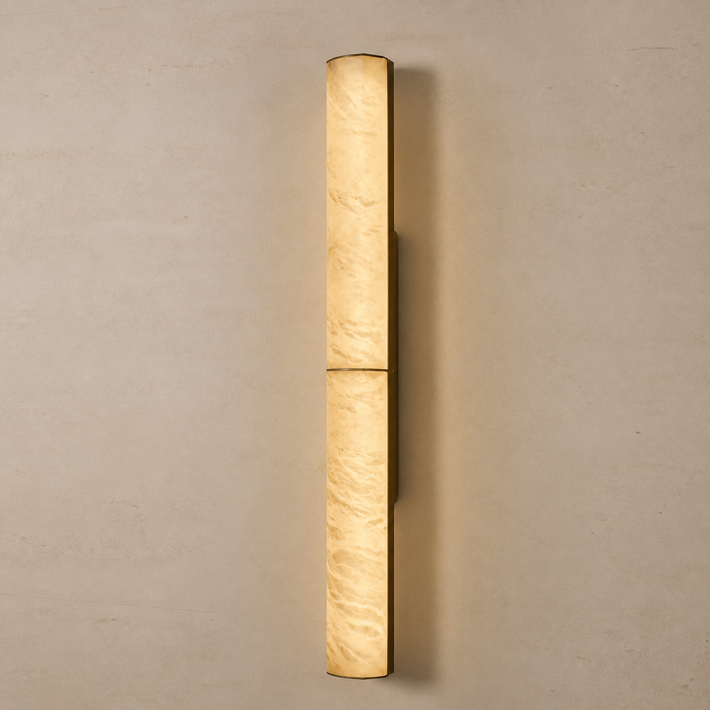 Caldera alabaster column wall sconce illuminated on a warm neutral wall